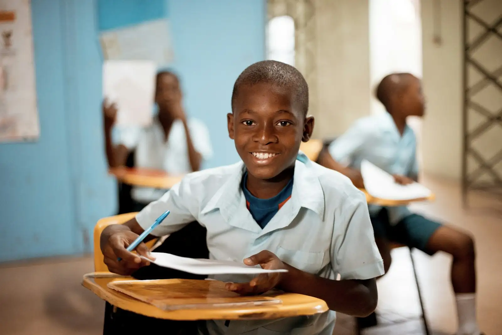 A schoolchild holding up work in a classroom