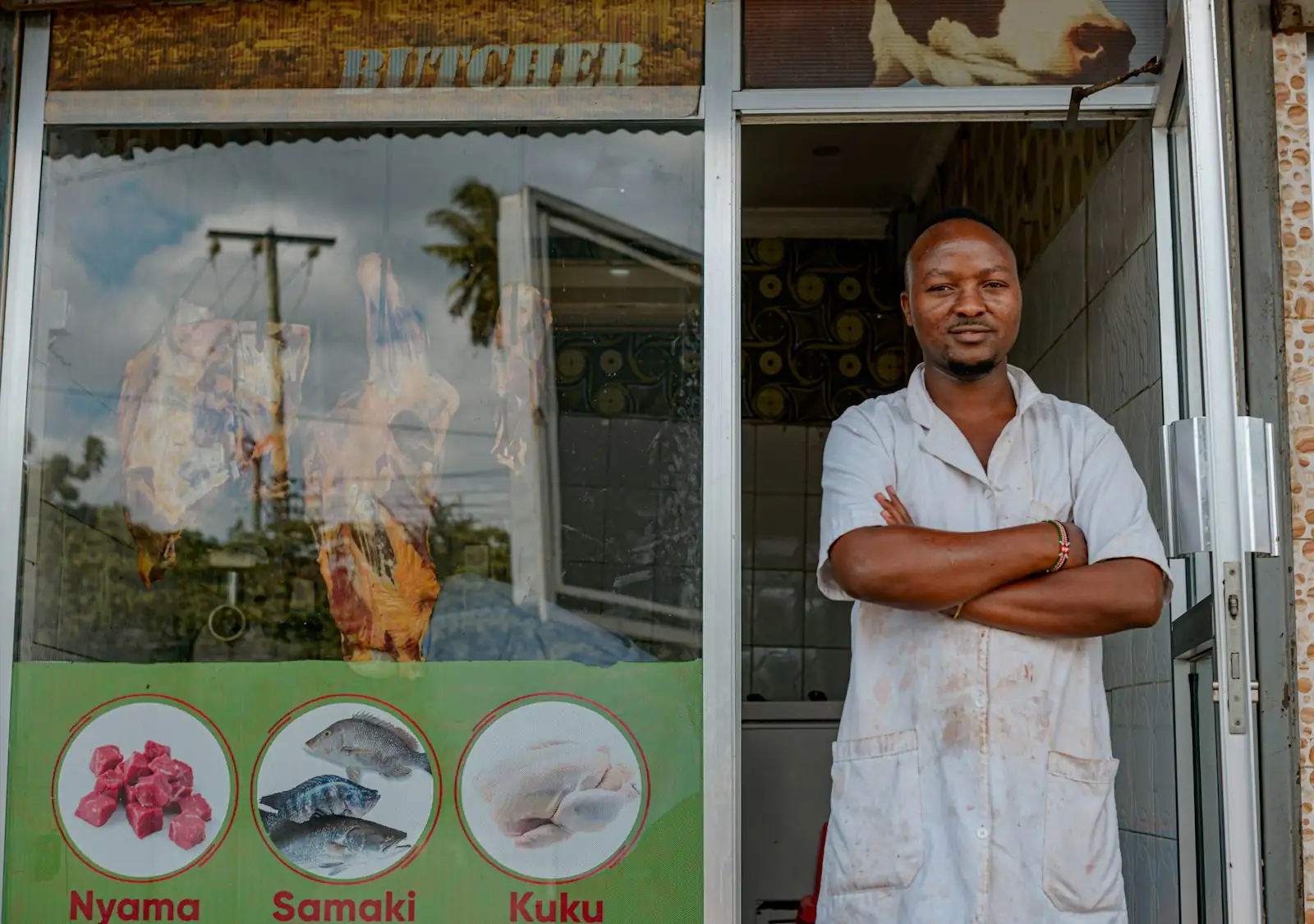 A butcher standing in the shop doorway